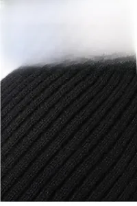 Detailed close-up of thick black ribbed knit fabric showing warm winter texture