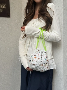 Lifestyle detail view of a quilted cartoon dog print drawstring bag held by a model
