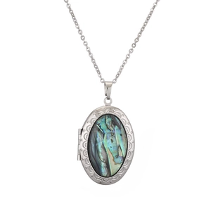 Detailed close-up of oval locket necklace featuring natural abalone shell and silver chain