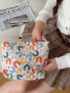 Quilted floral cosmetic bag with colorful abstract patterns and secure zipper closure