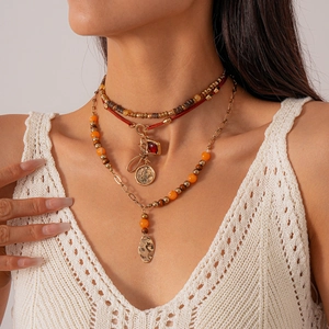 Detail of bohemian layered necklace with wooden beads and gold charms on model neck