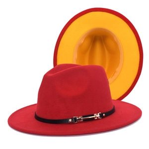Detail of red wool fedora with yellow lining, black leather band, and gold buckle