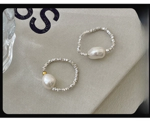 Macro detail of S925 silver baroque pearl rings with irregular texture and gold accents