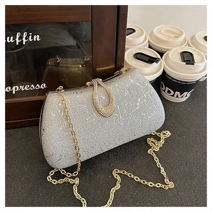 Detail of silver sequin evening clutch with gold chain and rhinestone ring buckle