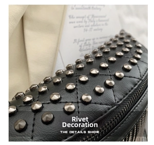 Detail showing black quilted leather bag with silver studs and metal zipper