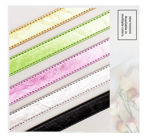 Detail showing five metallic textured leather belts with stitching and round silver buckles