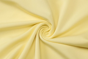 Dettaglio macro del tessuto a maglia giallo chiaro che mostra la consistenza morbida e fine