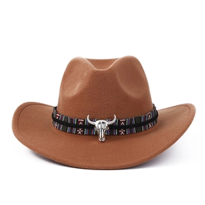 Détail d'un chapeau de cow-boy marron avec ruban ethnique et emblème de crâne de taureau argenté