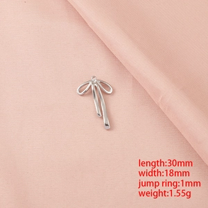 Détail d'un pendentif nœud argenté de 30x18mm avec dimensions sur tissu rose doux