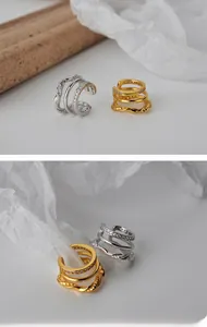 Close-up of triple-layered cuff earrings with pavé zircons and twisted rope texture