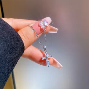 Detailed close-up of sparkling square zircon cross pendant on a thin silver chain