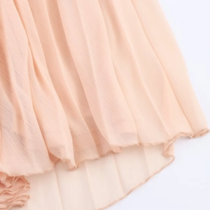 Detail of pleated apricot chiffon skirt hem with fine stitching and airy texture