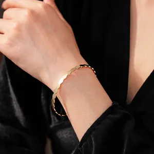Minimalist twisted geometric open cuff bracelet in 18K gold finish with wavy edges