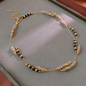 Detailed view of double-layered agate bead necklace on grey velvet display tray