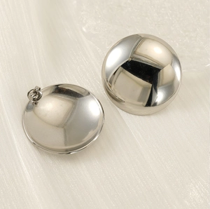 Vue macro des boucles d'oreilles rondes géométriques argentées au fini poli