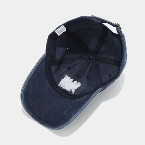 Detail of 100% cotton washed denim baseball cap featuring inner seams and metal buckle