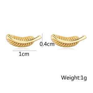 Detalle de los pendientes de pluma dorados con dimensiones de 1cm de largo y 0,4cm de ancho