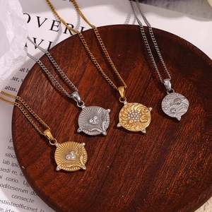 Macro detail of vintage 18K gold plated tarot sun and moon pendants on a wooden tray