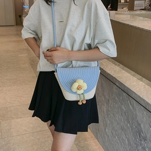 Fashionable woven straw bucket bag with floral accent and crossbody strap for beach