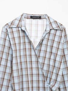 Detail der blau-braun karierten Popeline-Bluse mit V-Ausschnitt und Taillen-Knopf
