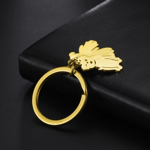 Close-up of golden cartoon poodle keychain on black leather texture background