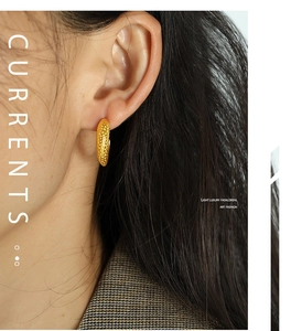 Detailed close-up of golden textured irregular moon stud earring on a model ear