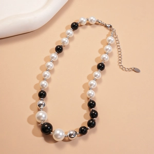 Detail of black and white imitation pearl beaded necklace with silver extender chain
