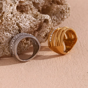 Detail of 18K gold and silver plated crossover rings with braided texture and crystals