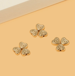 Macro shot of three groups of golden heart-shaped beads for DIY jewelry making