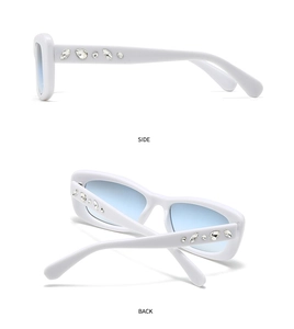Detail view showing white frame sunglasses with blue gradient lenses and rhinestone temple