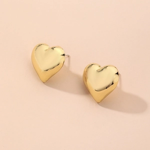 Vue détaillée de boucles d'oreilles cœur dorées avec une finition métallique minimaliste