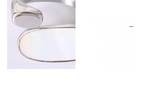 Gros plan détaillé d'une bague ouverte en argent avec une incrustation ovale en nacre blanche