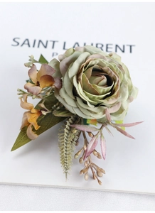 Detailed macro view of a vintage dusty green rose corsage with silk petals and leaves