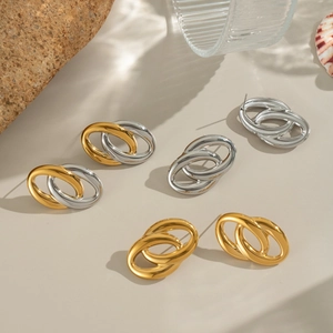 Dettaglio di orecchini a cerchio ovali in oro e argento su oggetti di scena artistici