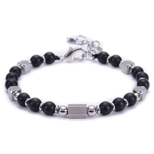 Close-up of adjustable matte black beaded bracelet with hexagonal silver charms