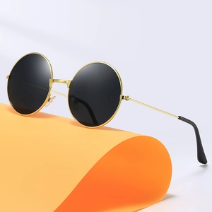 Retro-Rundsonnenbrille mit Goldrahmen und dunklen Gläsern auf orangefarbenem Stand