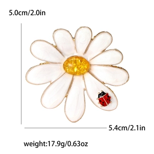 Elegant daisy flower brooch with red ladybug and amber center on white background