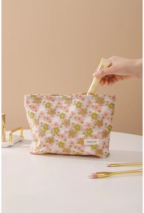 Floral mesh cosmetic bag showing hand placing skincare products inside the pouch