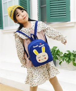 Detailed view of the cute blue rabbit print canvas backpack for toddler girls on a model