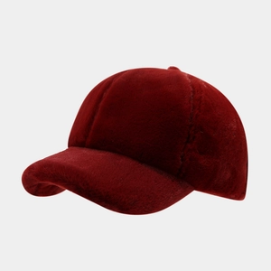 Macro shot of plush wine red baseball cap showing soft faux fur texture and stitching