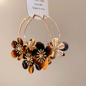 Detail of leopard print fabric flower hoop earrings with a gold metallic flower center