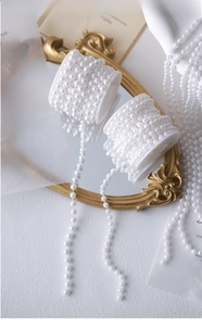 Close-up of white pearl beads on spools for DIY vintage necklace and crafts