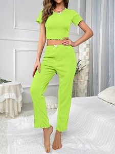 Detail of neon green ribbed loungewear set featuring sweet white bow accents and wavy edges