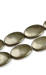 Detaillierte Makroansicht von ovalen Pyrit-Perlen mit Metallglanz für DIY-Schmuckherstellung