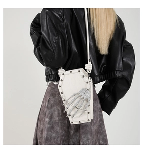 Gothic white coffin crossbody bag with skeleton hand and silver studs on black leather jacket