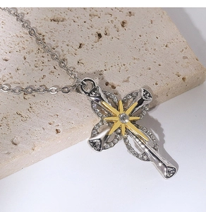 Close-up of double layer silver necklace with a crystal-encrusted cross and golden star charm