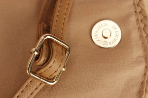 Close-up of brown textured leather strap with gold metal buckle and magnetic closure