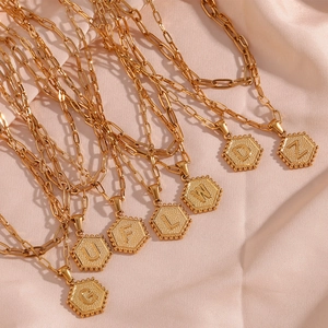 Double-layer paperclip chain necklace with gold hexagonal letter pendant on silk
