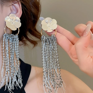 Detail of elegant floral earrings with cascading metallic silver tassel beads for women