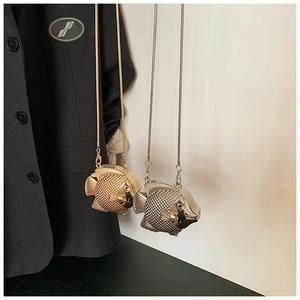 Detailed view of fish-shaped metallic crossbody bag with textured scales and chain strap